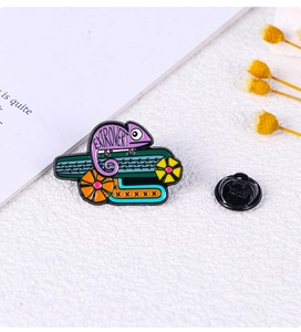 Macro shot of purple chameleon enamel pin with Extrovert engraving and butterfly clutch