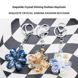 Close-up of crystal flower keychains in blue, gold, and white with silver lobster clasps