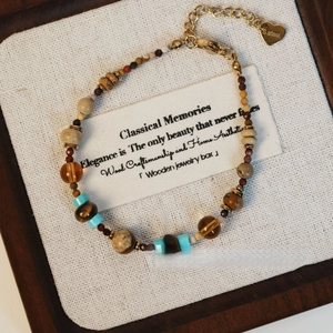 Détail d'un bracelet de perles vintage avec pierres et breloque en forme de coeur