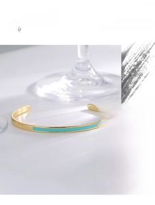 Minimalist C-shaped gold bangle featuring an elegant turquoise enamel inlay detail