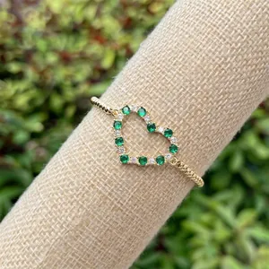 18k gold plated bracelet featuring hollow heart charms with green and white zircons