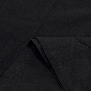 Close-up of black linen texture and double-stitch detailing on summer polo shirt