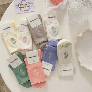 Combed cotton socks with tulip embroidery in pastel colors on a stylish table setup