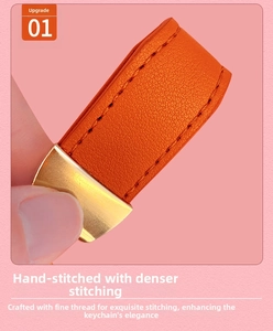 Detailed close-up of orange leather keychain with handmade stitching and gold metal clasp