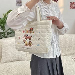 Close-up of quilted cotton tote bag with cute dog embroidery and decorative slogans
