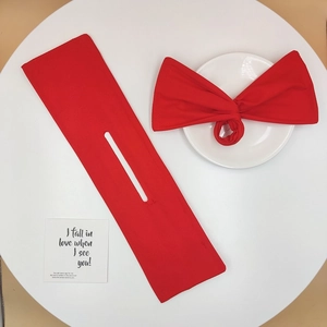Detail showing red floral bun maker set with bow scrunchie on a clean white surface