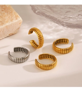 Detail of vintage striped C-shape rings in gold and silver finish with textured surface