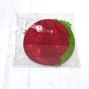 Detail of red and green strawberry party swirl decorations with hooks in polybag packaging