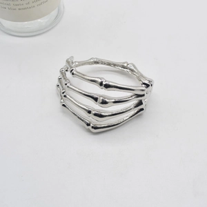 Detailed view of silver skull hand bone bracelet with adjustable multi-ring metal design