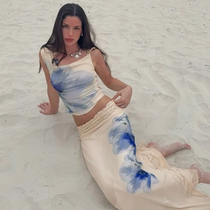 Chic cream two-piece set with blue floral print, off-shoulder top and maxi skirt on beach