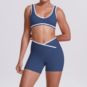 Women's two-piece sports set in navy blue with white trim and crossover high waist shorts