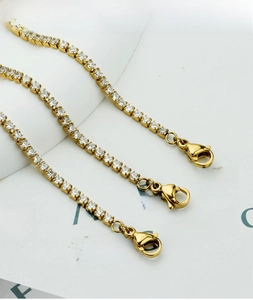 Close-up of gold titanium steel bracelets with cubic zirconia inlays and secure clasp details