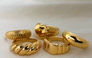Set of five gold stainless steel rings featuring heart, twisted and geometric textures