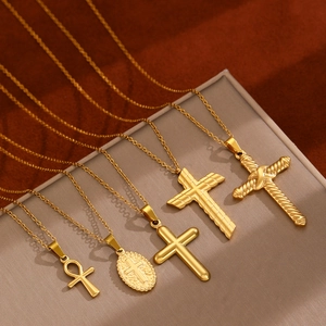 Collection of five assorted gold-tone stainless steel cross pendant necklaces on display