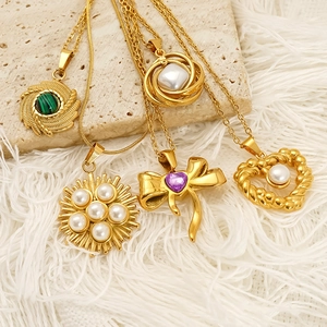 Gold plated vintage necklaces set featuring pearls and turquoise stones on stone backdrop