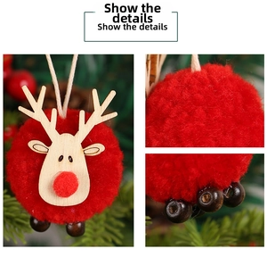 Detail view of a red pompom reindeer ornament with wooden head for Christmas tree decor