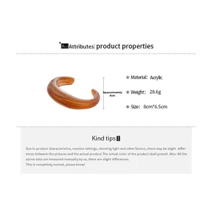 Detailed view of amber acrylic bangle showing 8x6.5cm dimensions and glossy texture