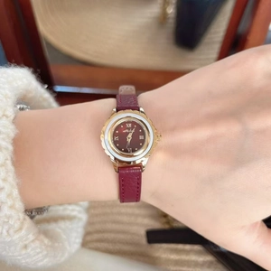 Close-up of model wearing Mikot women's watch with burgundy leather strap and gold case