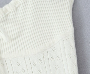 Gros plan sur un tissu en maille côtelée blanche avec des motifs ajourés et texturés