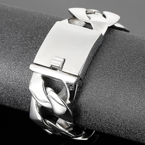 Macro detail of silver stainless steel Cuban link bracelet with wide insert clasp