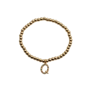 Detailed shot of golden bead bracelet with colorful zircon letter Q pendant