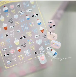 Detail showing cute cartoon dog and cupcake nail stickers applied on manicure samples
