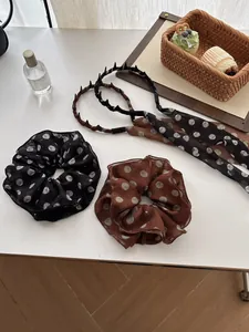 Close-up of chiffon polka dot hair scrunchies and ribbons on a white decorative table