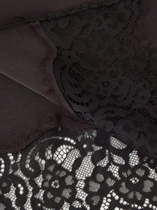Makro-Detail der schwarzen Spitzenborte und Satin-Chiffon mit feiner Stickerei