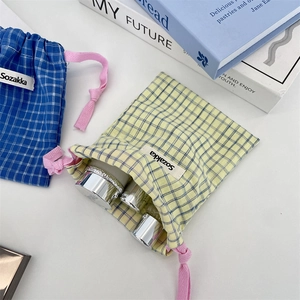 Detail of plaid cotton drawstring storage bags in yellow and blue showing fabric texture
