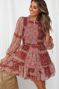 Detail of red paisley floral dress featuring smocked waist and ruffled hemline
