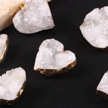 Detailed view of heart-shaped white druzy crystal pendants with gold plated edges