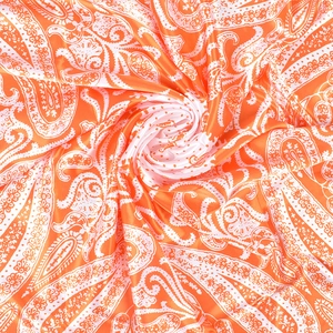 Detailed view of paisley patterns on orange and white satin silk square scarf fabric