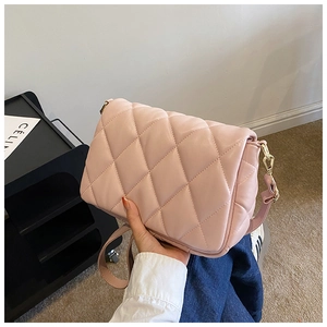 Detailed shot of pink quilted crossbody bag with gold hardware and stylish chain strap