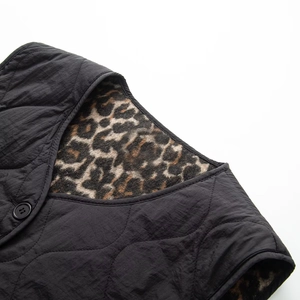 Detail of black quilted vest featuring leopard print fleece lining and round neckline