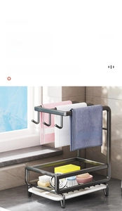 Detail of black wall-mounted kitchen rack with towel hooks and removable drain tray