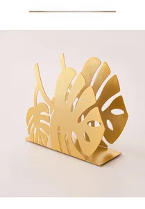 Macro detail of the matte gold finish on the iron monstera leaf napkin holder