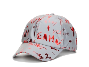 Detail of grey baseball cap featuring red reflective pop art patterns and trendy letters