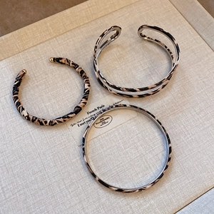 Detail of vintage leopard print bangle set including twisted and open cuff designs