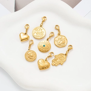 Assorted vintage gold stainless steel charms featuring coins and heart shapes on tray
