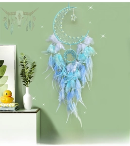 Detailed view of handmade moon dreamcatcher with blue feathers and tree of life charm