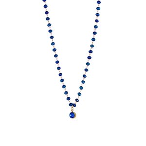 Detail of beaded necklace with navy blue faceted tubes and round gemstone pendant