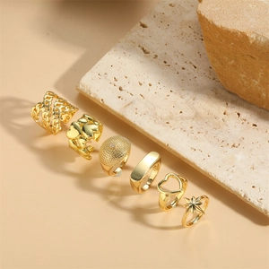 6-piece gold-tone vintage ring set with heart and star designs on a stone background