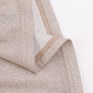 Gros plan d'un tissu champagne doré scintillant avec paillettes métalliques et couture