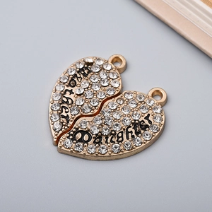 Close-up of golden heart pendants with rhinestones engraved with Mother and Daughter