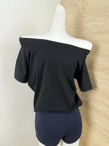 Close-up of black off-the-shoulder short sleeve top with minimalist draped design