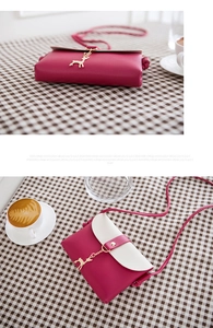 Close-up of rose pink and white PU leather crossbody bag with golden deer pendant
