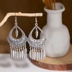 Detailed close-up of retro silver tassel earrings with delicate bohemian leaf motifs