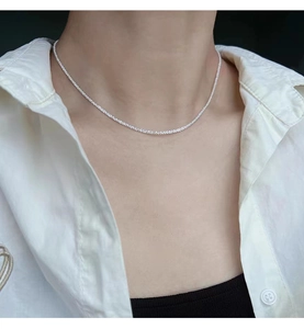 Close-up of minimalist 925 silver necklace on a model showing shimmering elegant texture