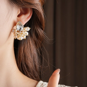 Close-up of model wearing water-drop pearl earrings with sparkling inlaid rhinestones