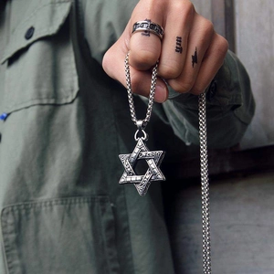 Detail of silver hexagram star pendant with scroll pattern on a classic box chain necklace